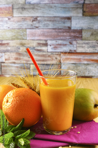 Healthy fresh pressed mango and orange juice with grains and min