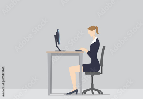 A woman working at her office desk, in front of computer.