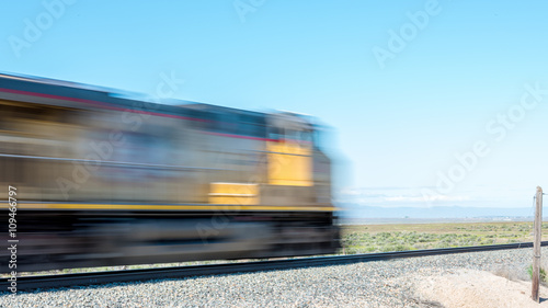 Blurred train engine passes quickly