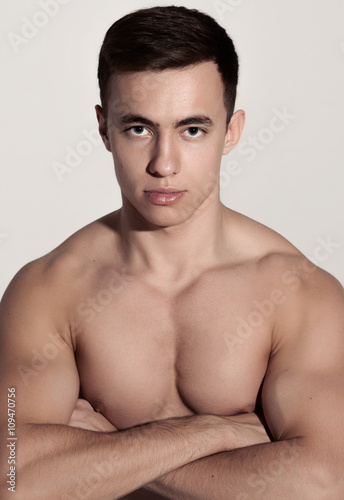 Sports man with crossed arms showing his biceps