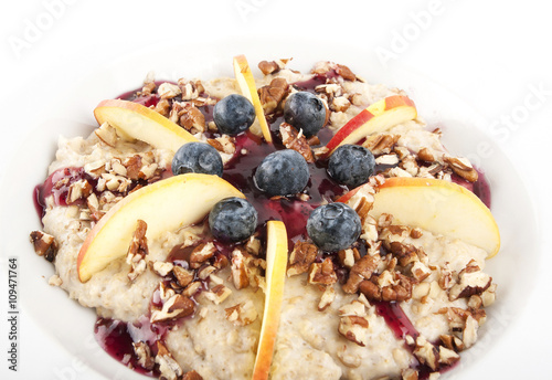 Oatmeal with apples, black berries, nuts and topping