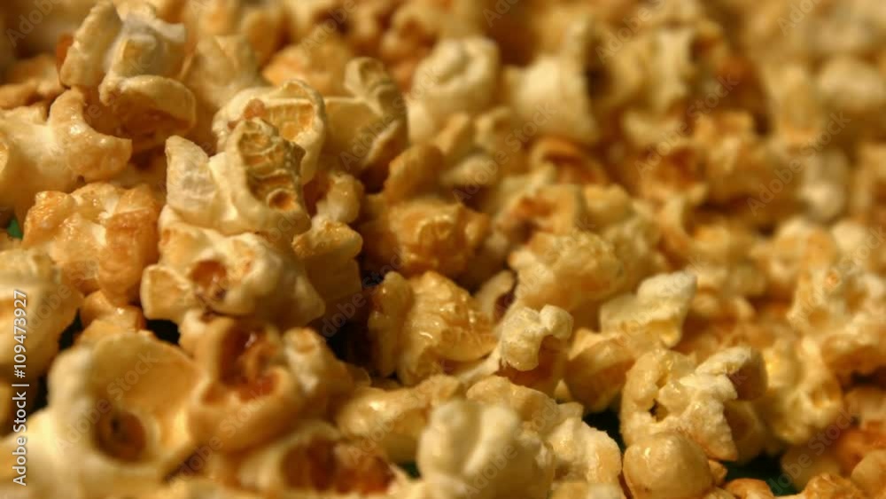 Popcorn on a green background. Slow motion. Close-up. Horizontal pan. 2 Shots