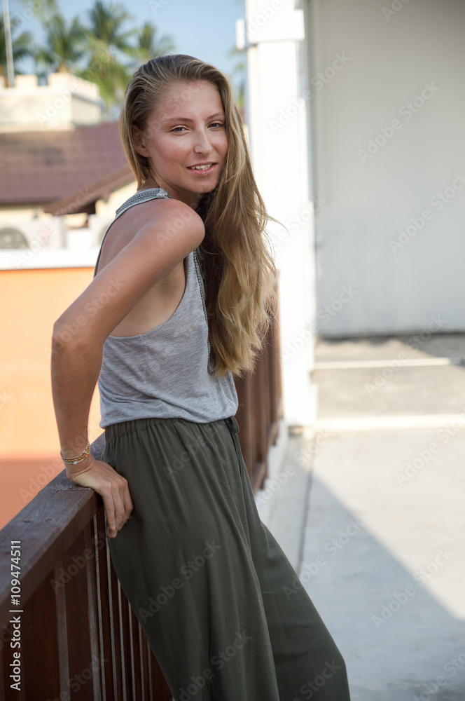 The beautiful blond girl posing on the street in fashionable clothes The beautiful blond girl posing on the street in fashionable clothes
