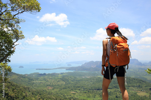 young woman hiker enjoy the view at seaside mountain peak
