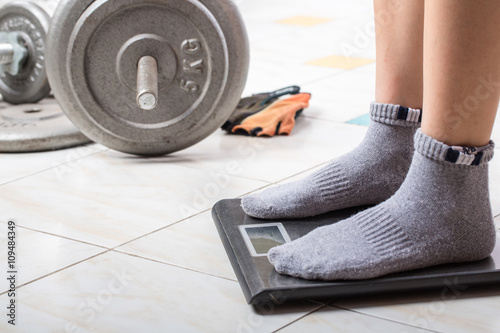 Close up female feet on digital weighting scel. photo