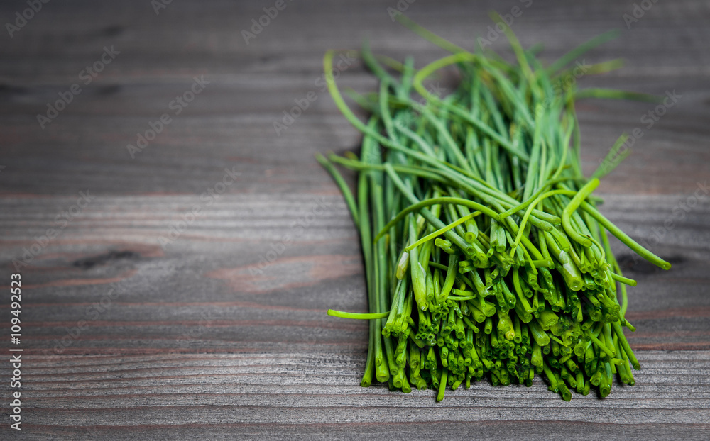 bunch of fresh chives on a wooden cutting board, selective focus bunch of fresh chives on a wooden cutting board, selective focus