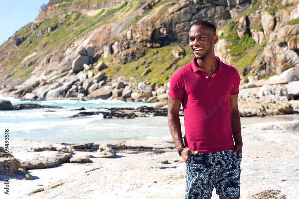 Cool young african guy smiling at the beach