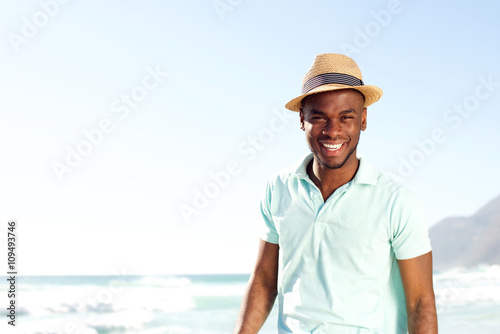 Cool young african man with hat at the beach