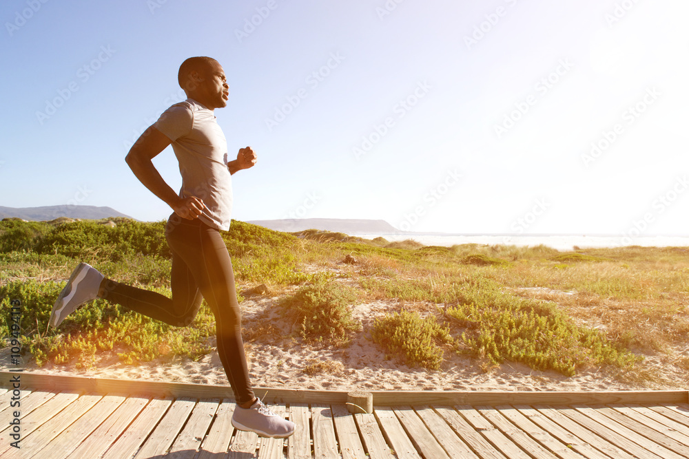 © mimagephotos - Fitness man running on the boardwalk at the beach © mimagephotos - Fitness man running on the boardwalk at the beach