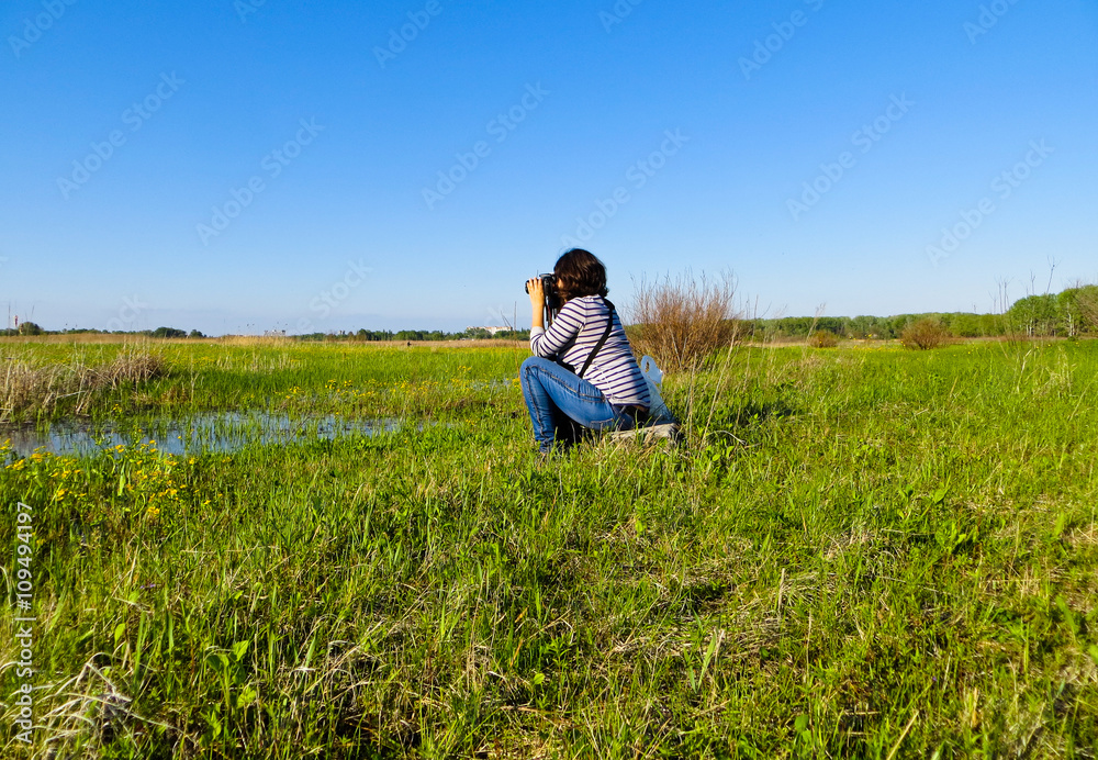 young woman photographer taking photo of the landscape young woman photographer taking photo of the landscape