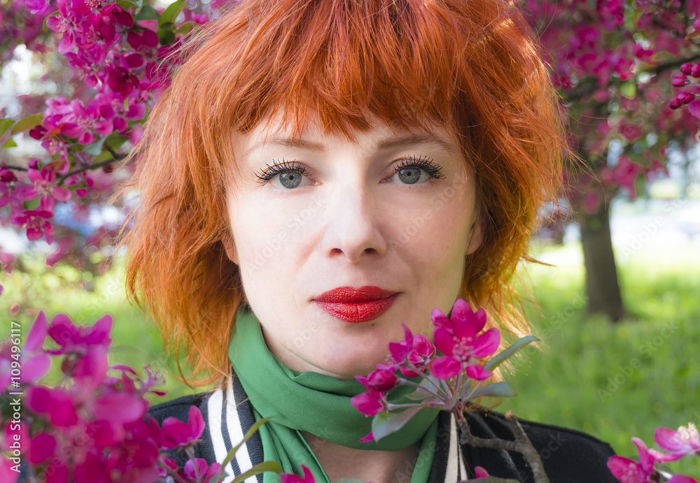 Beautiful woman's face among blooming heather flowers.