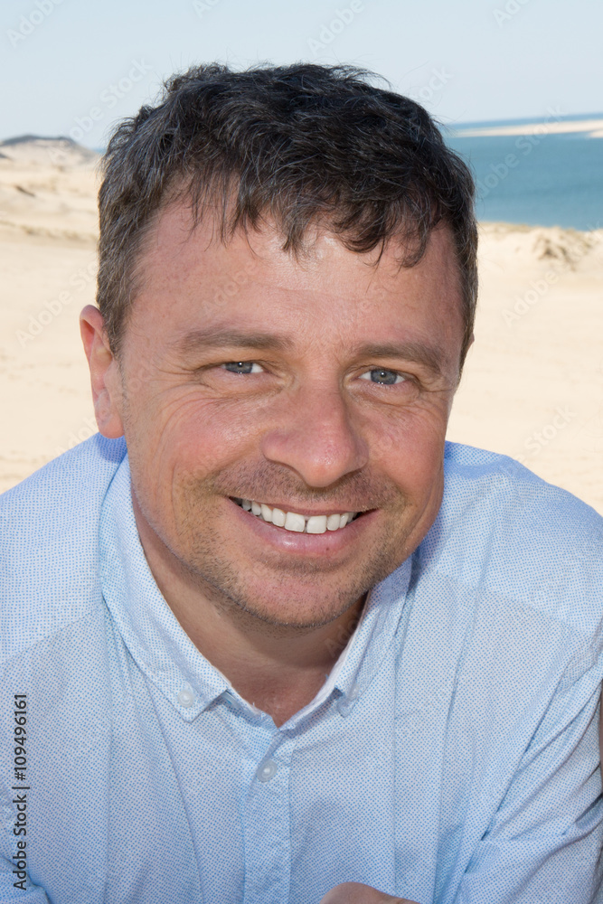 Good looking man wearing blue clothes by the sea