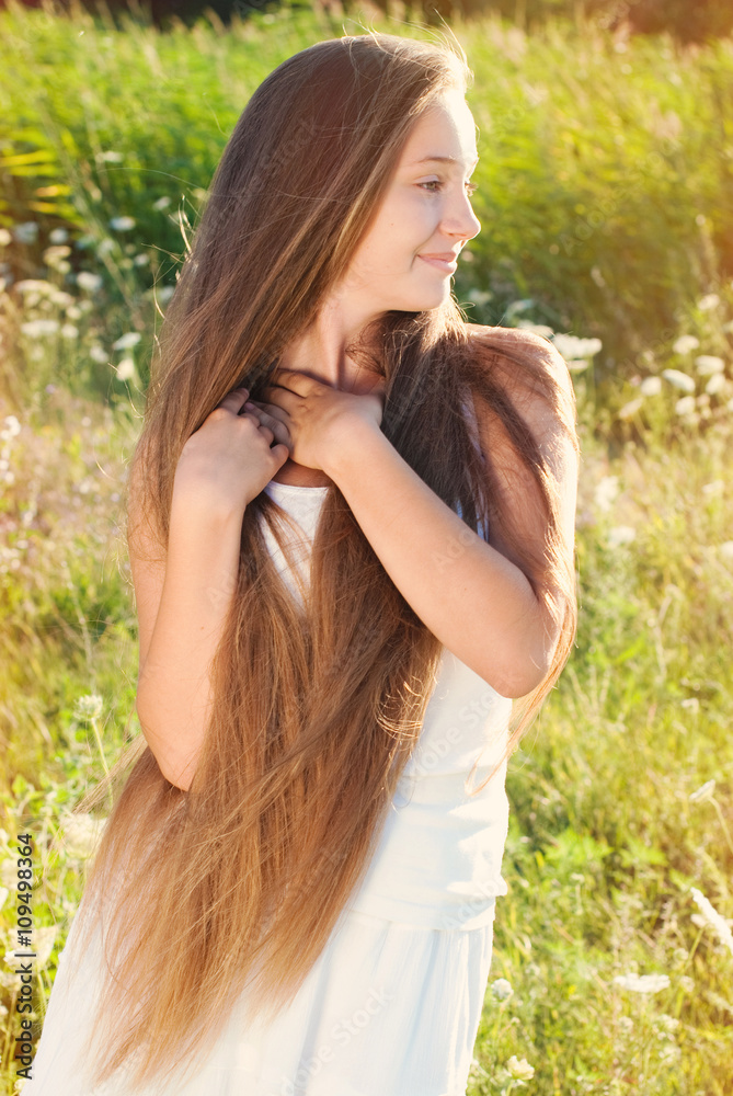 Fototapeta premium Beautiful Young Woman with long Hair in Sunset