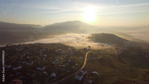 Aerial - Flying over the clouds at sunrise in the mountain  photo