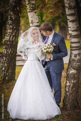Wedding couple with bouquet outdoors near birch. having fun embrace . emotional portrait. happy married