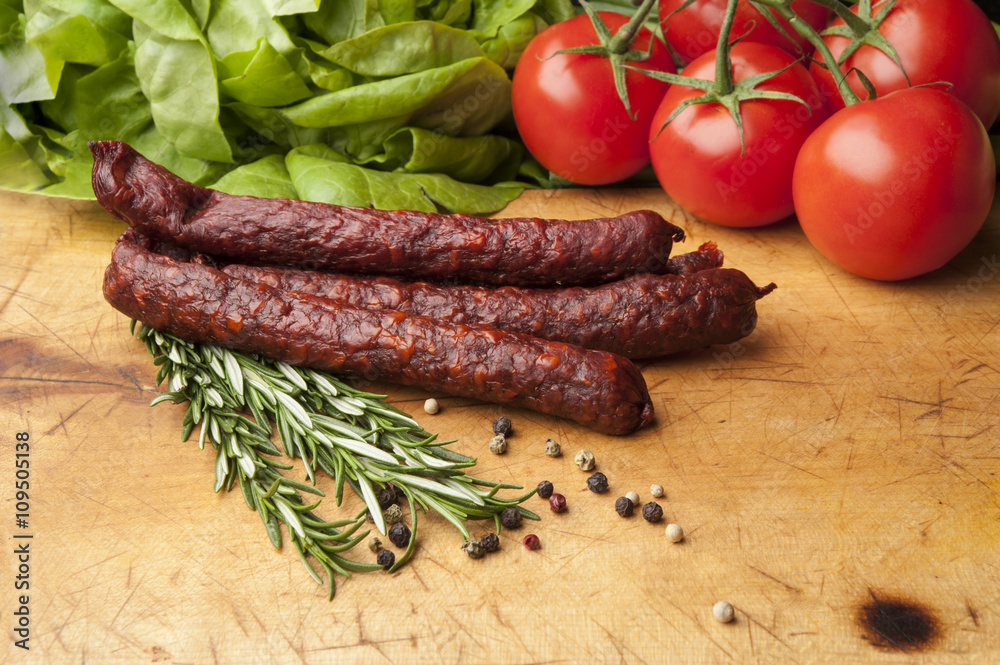 Sausage on a cutting board with tomato Sausage on a cutting board with tomato