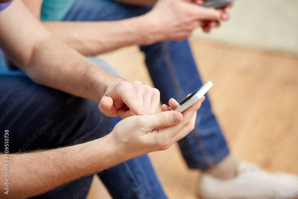 Obraz premium close up of friends with smartphones at home
