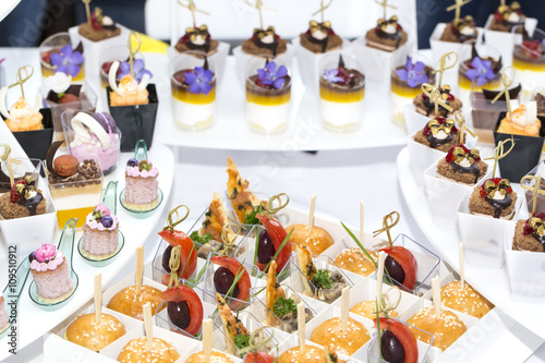 mini canapes in plastic cups decorated with edible flowers