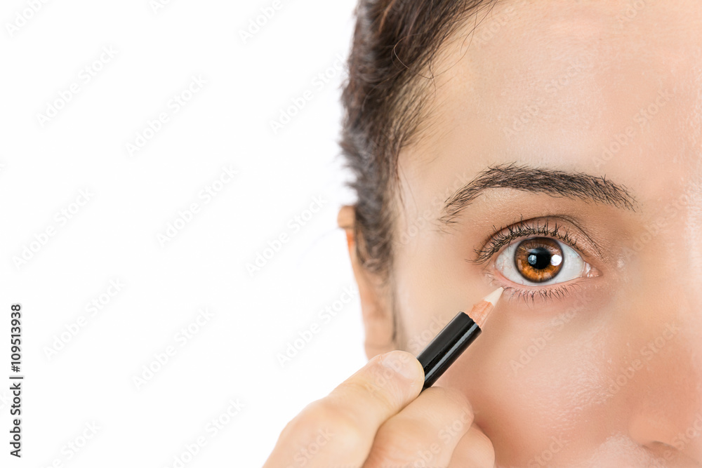 Close up of eye of a woman applying eyeliner Close up of eye of a woman applying eyeliner