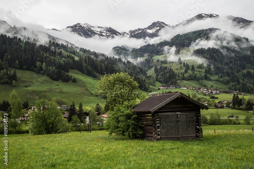 sanfte blühend Wiesen mit urigen Hütten und Heustadel vor idyllischer Bergkulisse in den Alpen