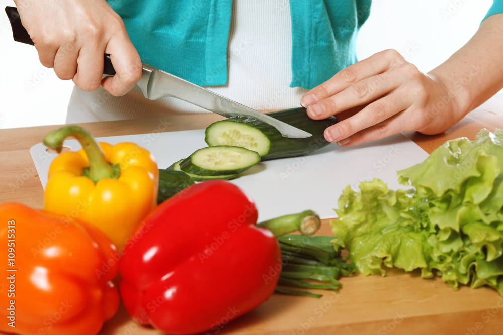 Girl is preparing salad. Fresh vegetables, peppers, cucumber, gr Girl is preparing salad. Fresh vegetables, peppers, cucumber, gr