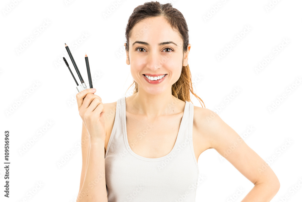 Happy make up woman showing her make up pens and brush Happy make up woman showing her make up pens and brush