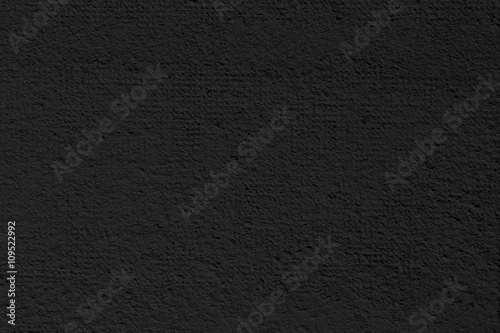 Cement or plaster wall. Black background.