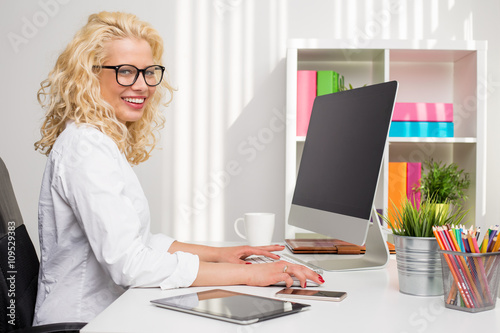 Woman working in the office on stationary computer