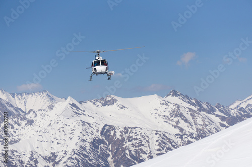 White rescue helicopter in the mountains