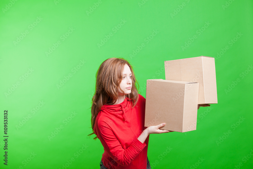 Woman holding cardboard boxes on green background Woman holding cardboard boxes on green background