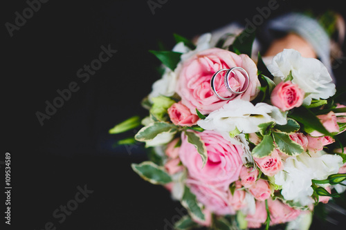 Pair or wedding rings on bouquet flower  focus on diamonds