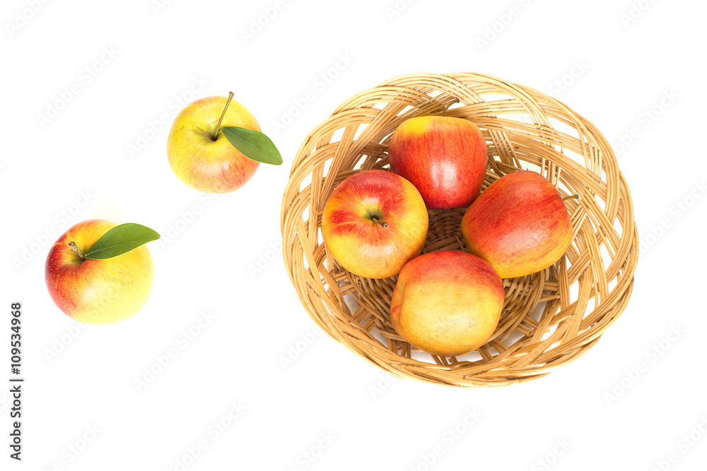Gala apples with green leaves on the basket