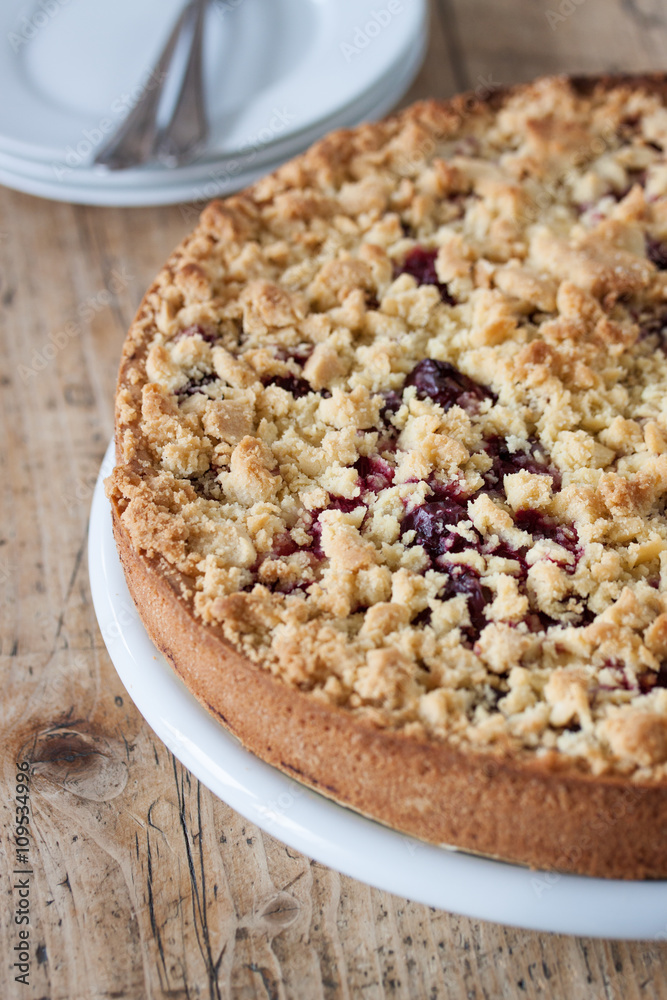 Homemade fresh sweet cherry crumble pie with whole wheat flour on a wooden table background ready to eat, closeup Homemade fresh sweet cherry crumble pie with whole wheat flour on a wooden table background ready to eat, closeup