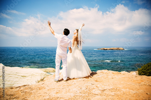 Elegant bride and groom walking on the beach, wedding ceremony, Mediterranean Sea. 