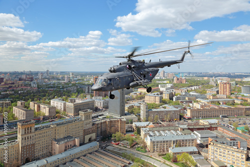 The helicopter flies over the city