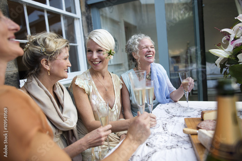 Elegant mature women enjoying champagne in urban garden photo