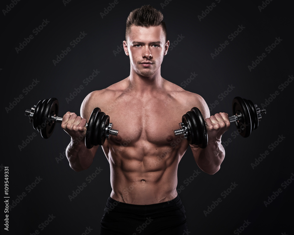 Bodybuilder doing exercises with dumbbells Bodybuilder doing exercises with dumbbells