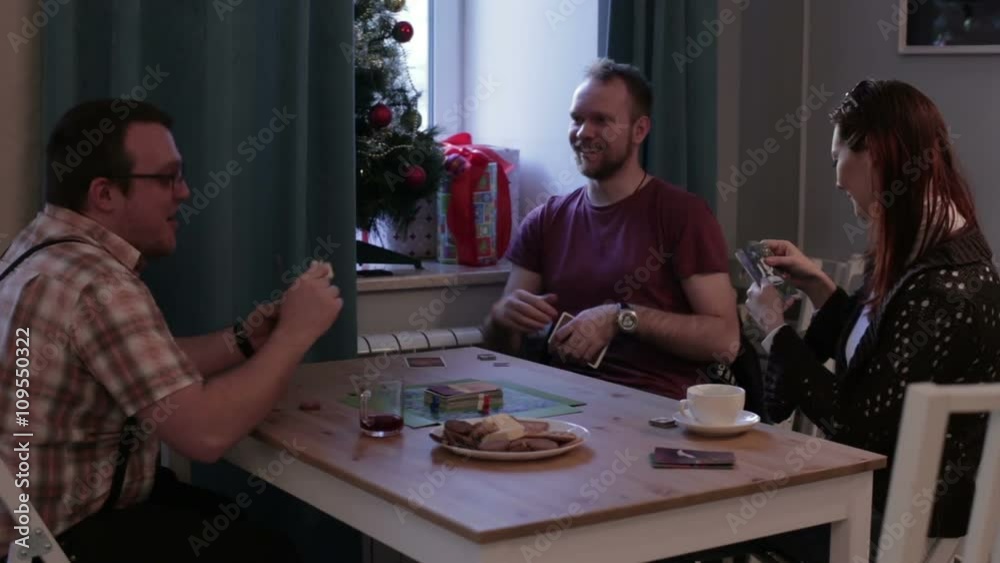 People at table playing a board game with cards People at table playing a board game with cards