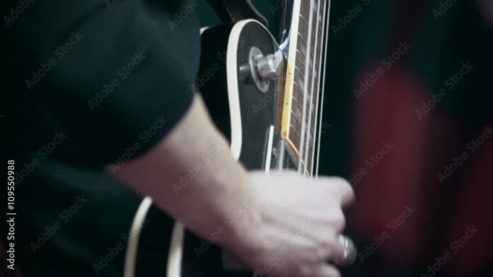 Musician playing bass guitar at studio, close up Musician playing bass guitar at studio, close up
