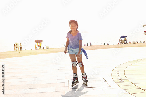 Girl rollerblading at beach, Zhuhai, Guangdong, China photo