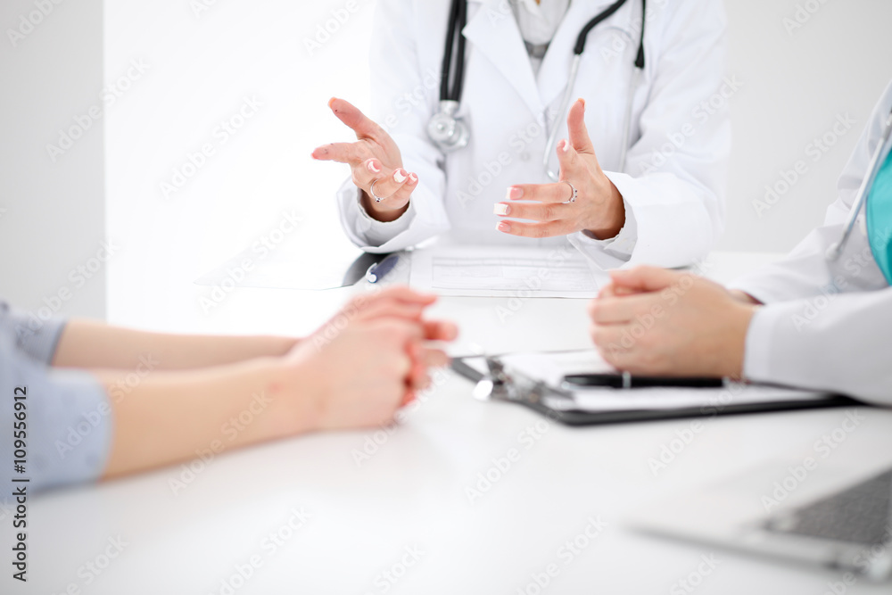 Doctor and patient are discussing something, just hands at the table Doctor and patient are discussing something, just hands at the table