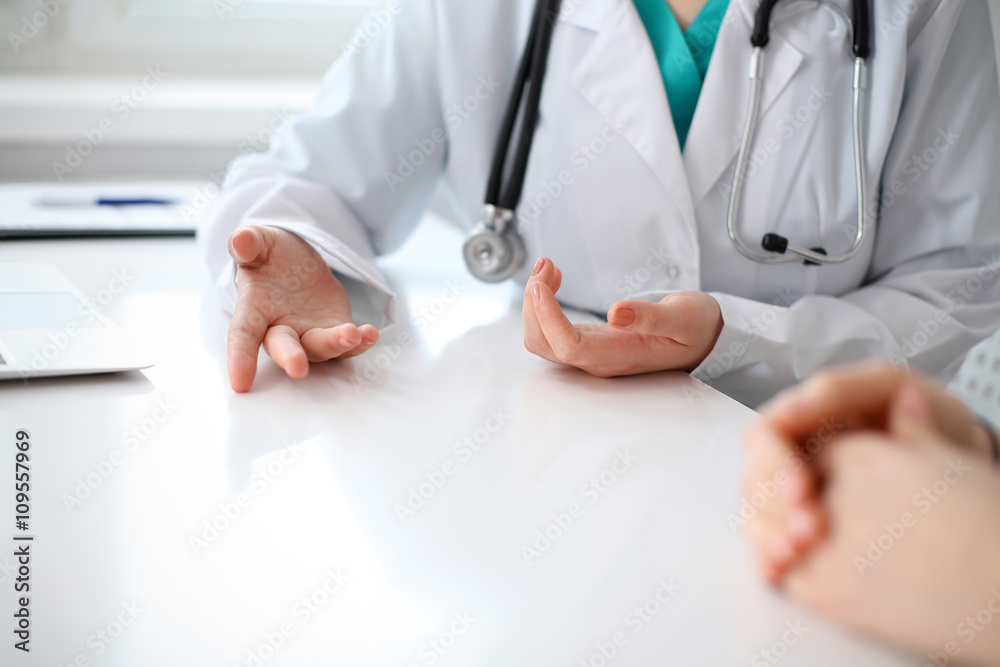Doctor and patient are discussing something, just hands at the table Doctor and patient are discussing something, just hands at the table