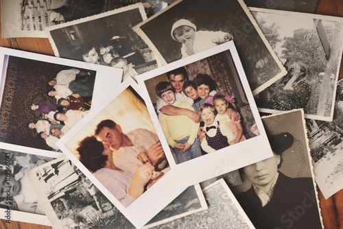 Pile of family photographs on table, overhead view photo