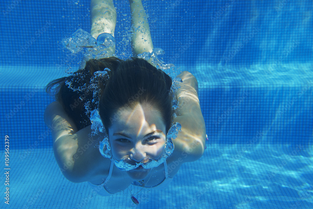 Underwater portrait of girl underwater swimming in swimming pool Stock