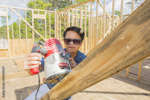 Mid adult woman using power tool, building her own home photo