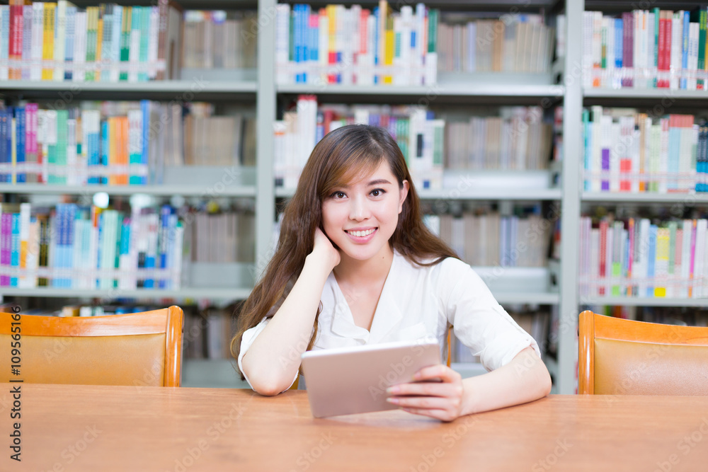 young beautiful asian girl with tablet in school library young beautiful asian girl with tablet in school library