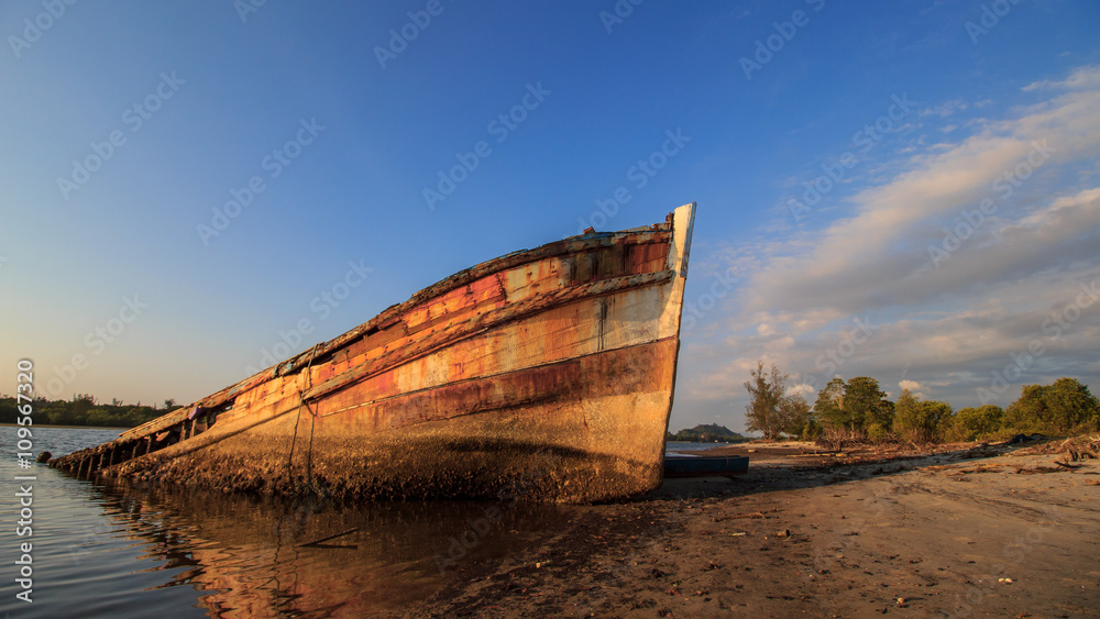 Abandoned Ship during sunset moment at sabah borneo malaysia Image has grain or blurry or noise and soft focus when view at full resolution. (Shallow DOF, slight motion blur)