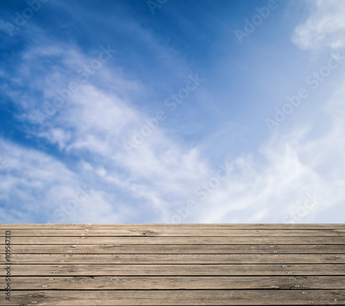 wooden floor with cloudy sky background