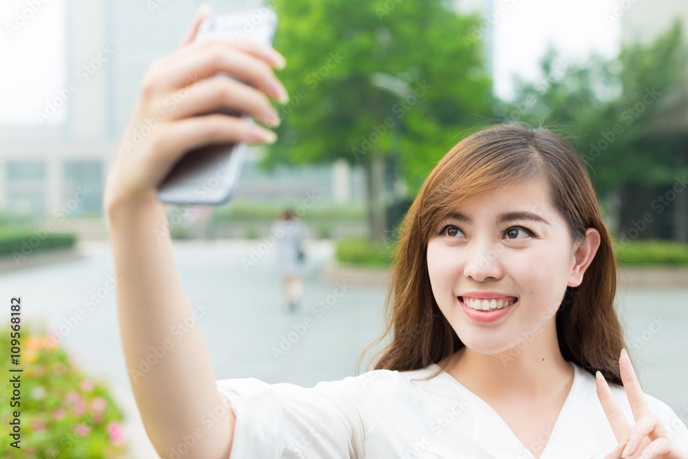 Fototapeta premium young beautiful asian girl with phone in school