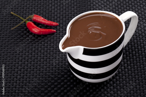 red chili with cup of melted chocolate